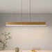 Modern dining area with a long rectangular table and gray chairs, featuring a pendant light.